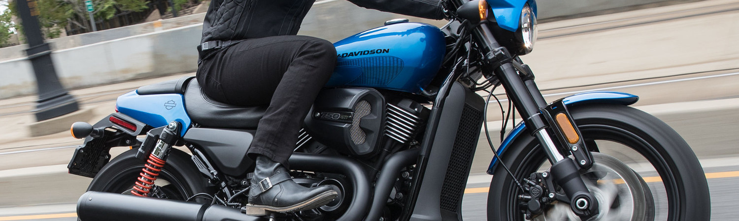 A person riding a Harley-Davidson® Street Road™ motorcycle on a city street